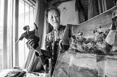 靳明展示她新制作的红色娘子军堆绣作品.